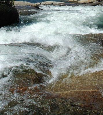 A close-up view of rushing water cascading over rocks in a stream or river