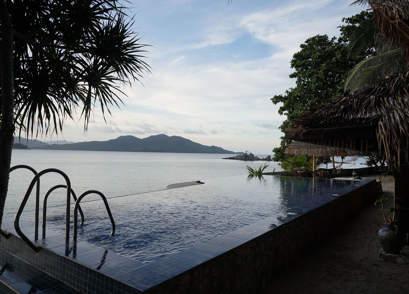 Infinity pool with view of the sea and coastline at Flower Island Resort.
