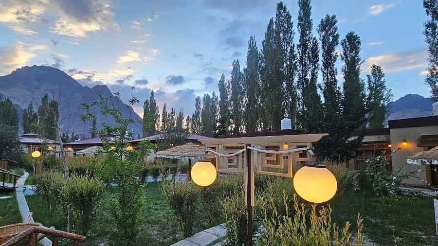 A wide angle view of White Sands Resort, Ladakh surrounded by lush greenery.
