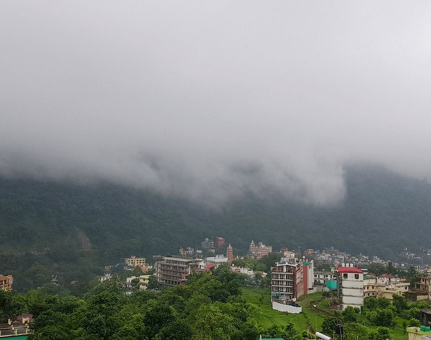A beautiful landscape of Rishikesh from the terrace of DLS Hotels On The Ganges with dense clouds floating in the sky.