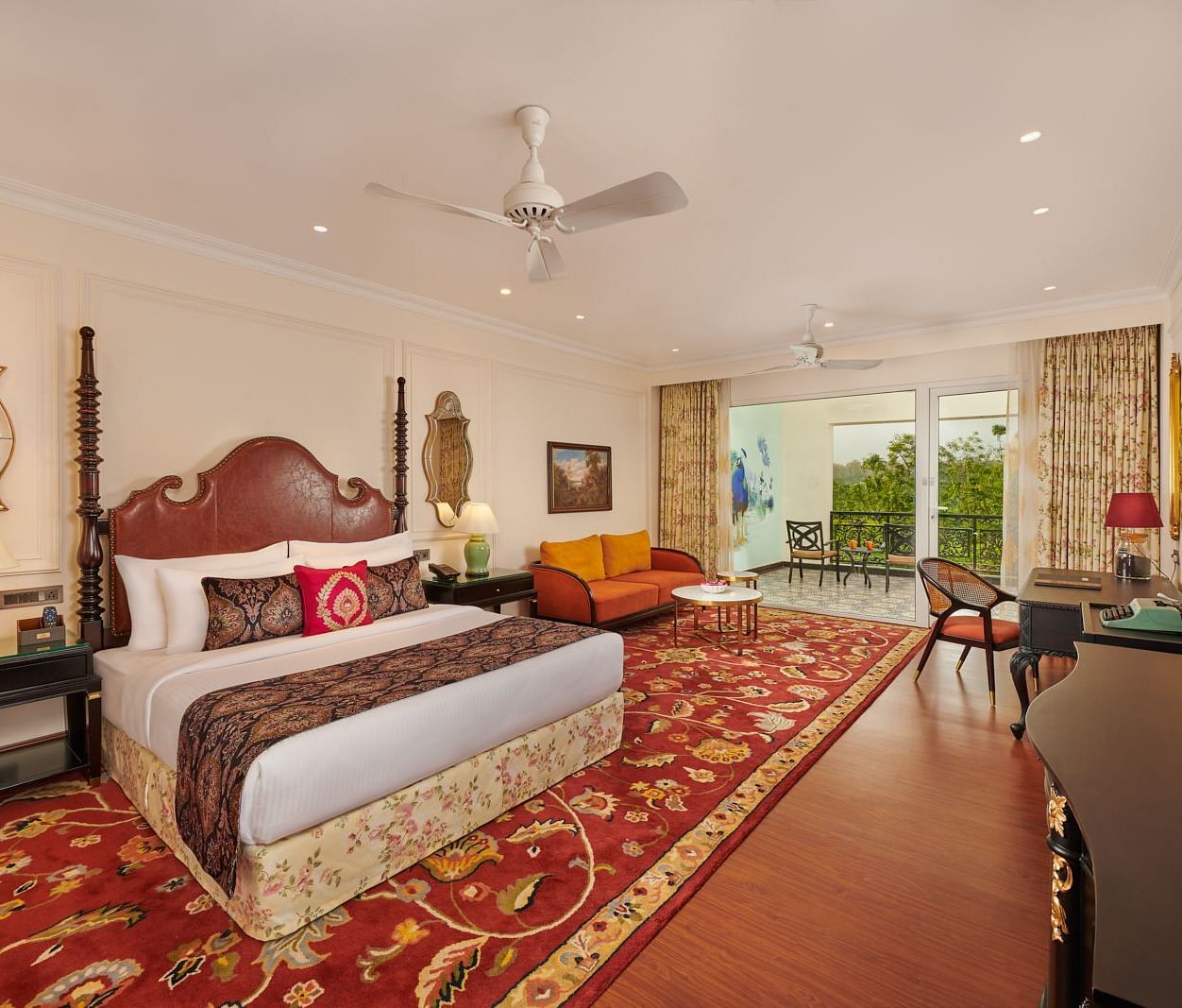 Grand bedroom with vibrant red carpet, antique furniture, and natural light.