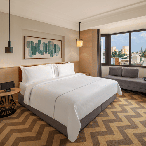 Suite room featuring a cozy bed and elegant bedside lamps at The Residency Chennai