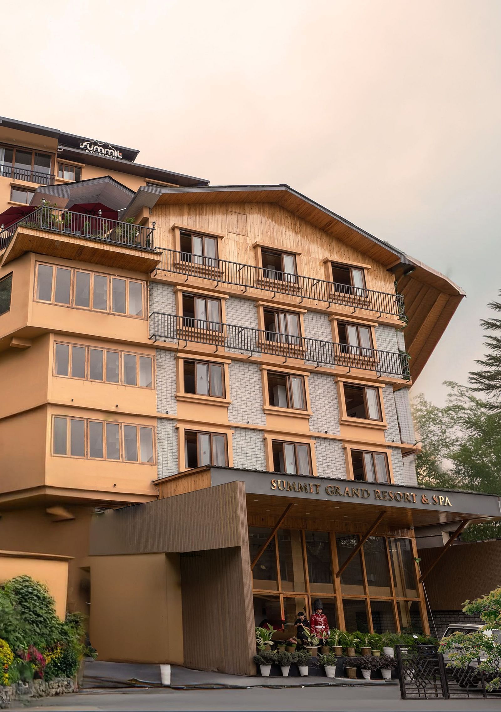 Facade image of Summit Grand Resort & Spa, Gangtok, with trees lining the pathway