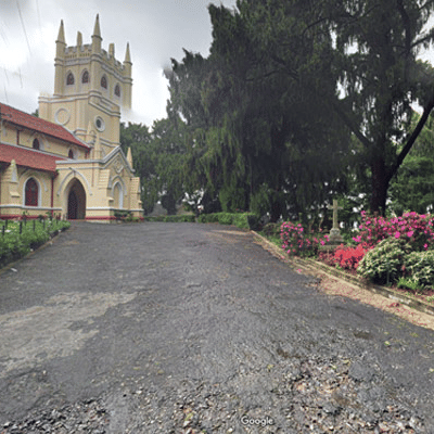 An old stone church with an expansive yard and a path leading up to the building, surrounded by greenery - Black Thunder, Coimbatore