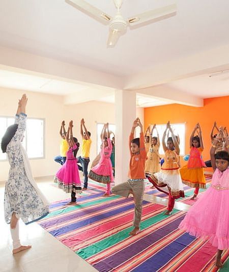 People performing yoga in colorful costumes, indoor setting - Shreyas Retreat