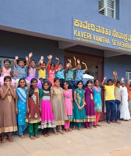 Group of people in colorful clothing standing outside a building, outdoor setting - Shreyas Retreat