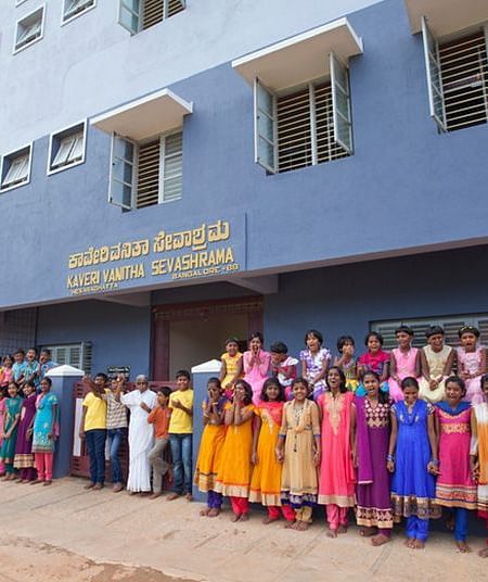 Group of people in colorful clothing standing outside a building, outdoor setting - Shreyas Retreat
