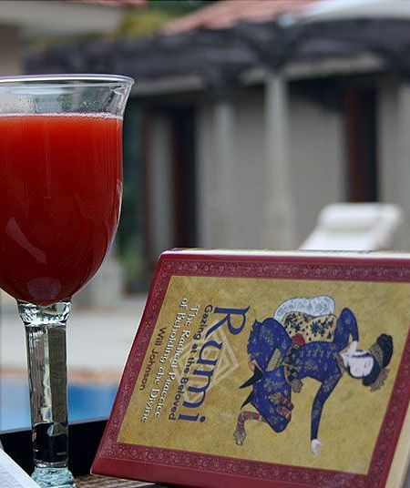 A table set outdoors with a drink, a book with a design - Shreyas Retreat
