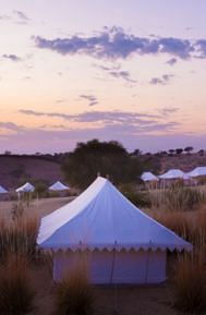 image of the tents at manvar resort and desert camp with mesmerising sunset with lavender and orange hues in the background - MANVAR Resort & Desert Camp