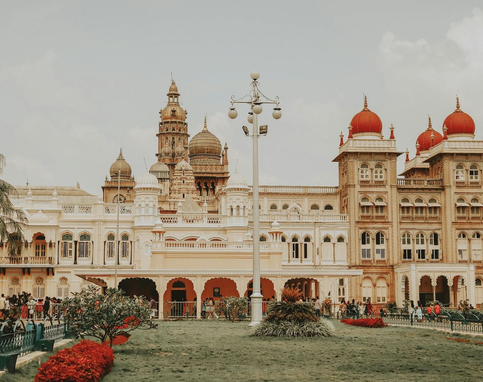 The facade of Mysore Palace with plants adorning the area in front.