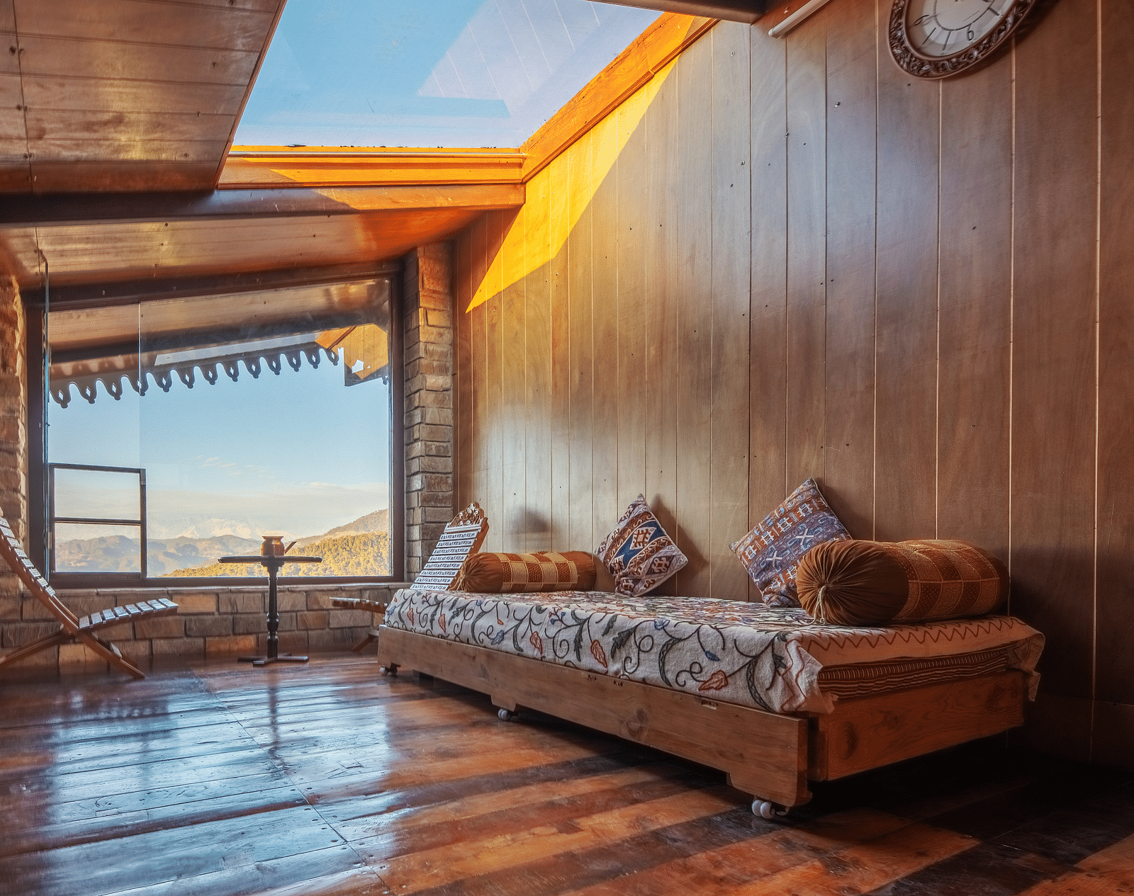 A scenic balcony view of a vibrant hillside village bathed in the warm hues of evening sunlight. - Blusalzz Homes The Himalayan Bungalow, Almora