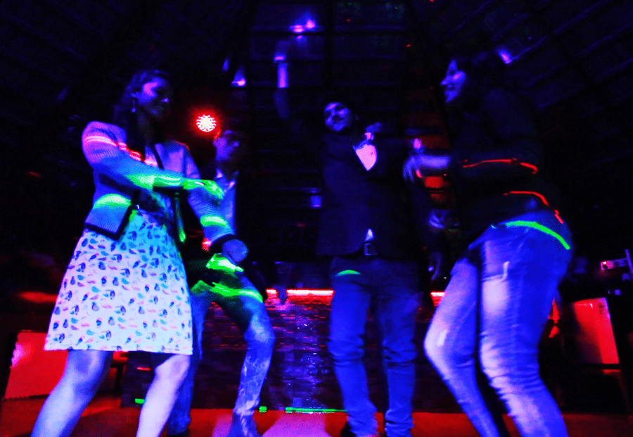 Image of a group of people dancing with disco lights beaming on them at Coorg Jungle Camp Backwater Resort, Kushalnagar.