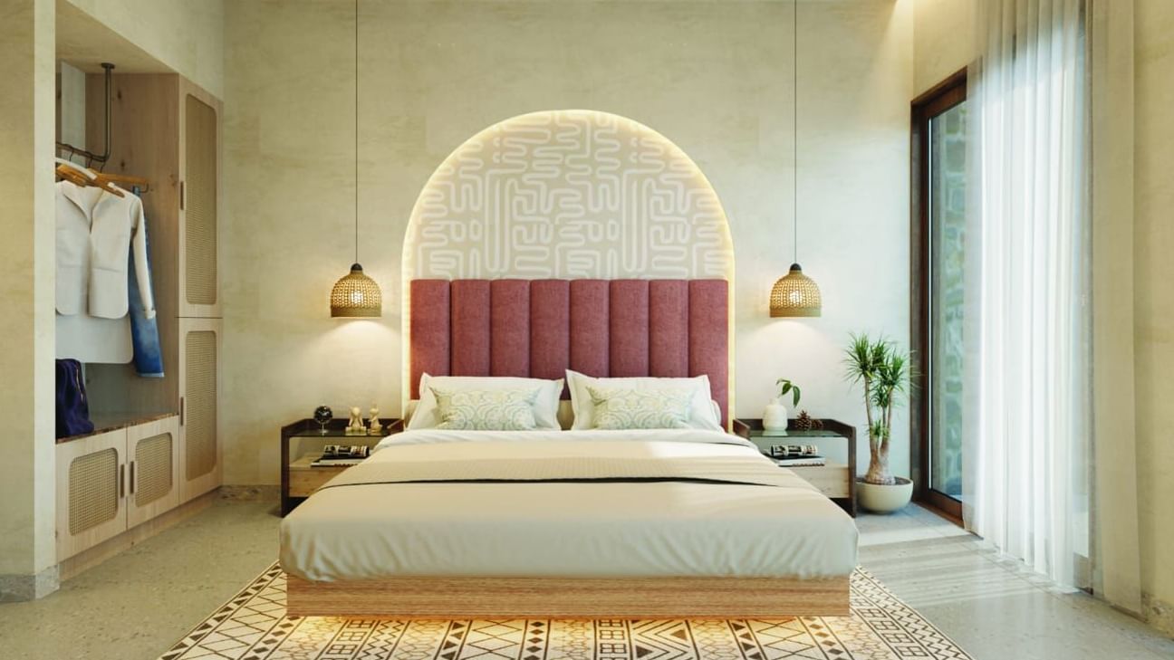 A well-lit, contemporary bedroom has a large bed, a curved arch, and an open wardrobe - Avanya Resorts Private Limited, Chennai