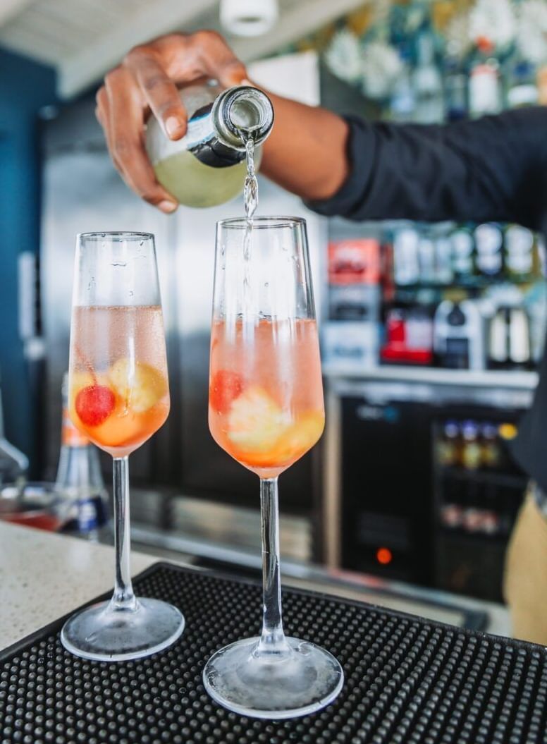 A bartendar making drinks on the counter table.