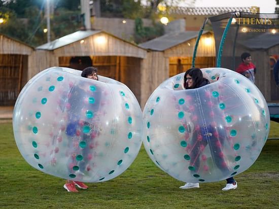 Two people playing in Zorbing Balls at Themis Mudhouse - A Nature's Retreat Resort & Wellness