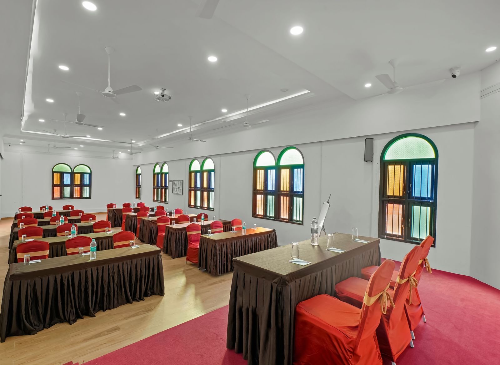 Diagonal view of a banquet hall with tables and chairs arranged for an event at WOW Bungalow, Yercaud.