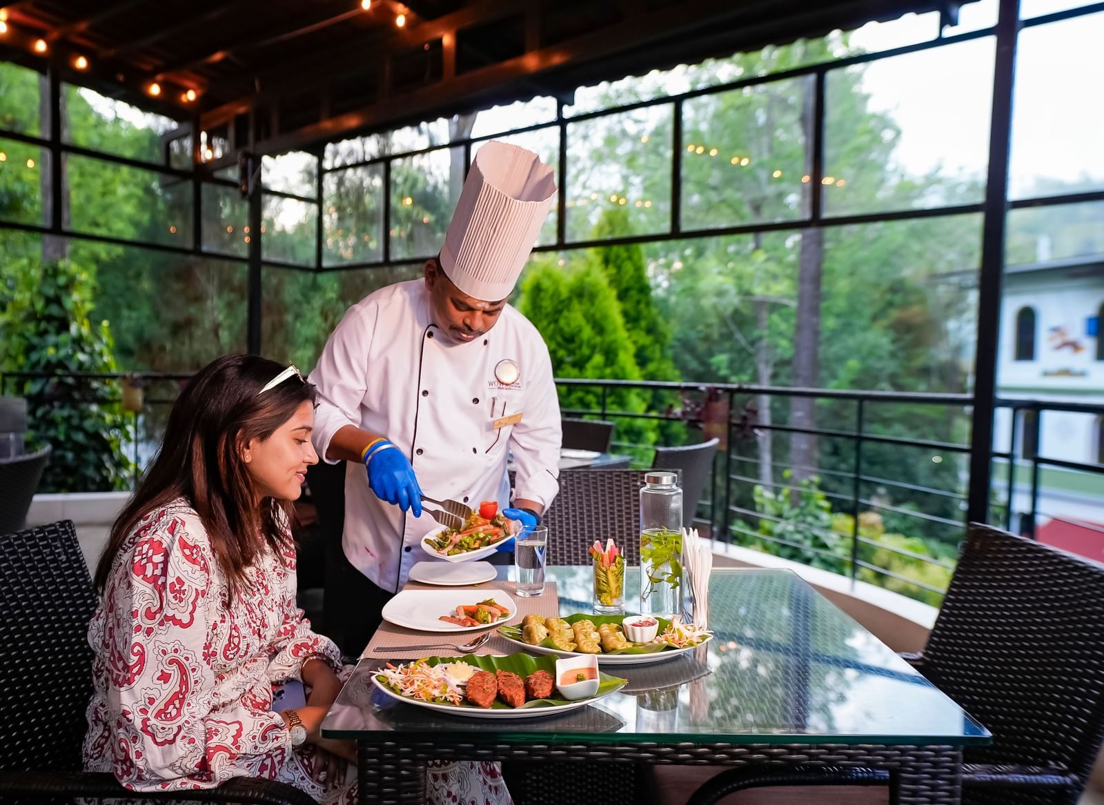 A chef serving food to a lady at WOW Bungalow, Yercaud.