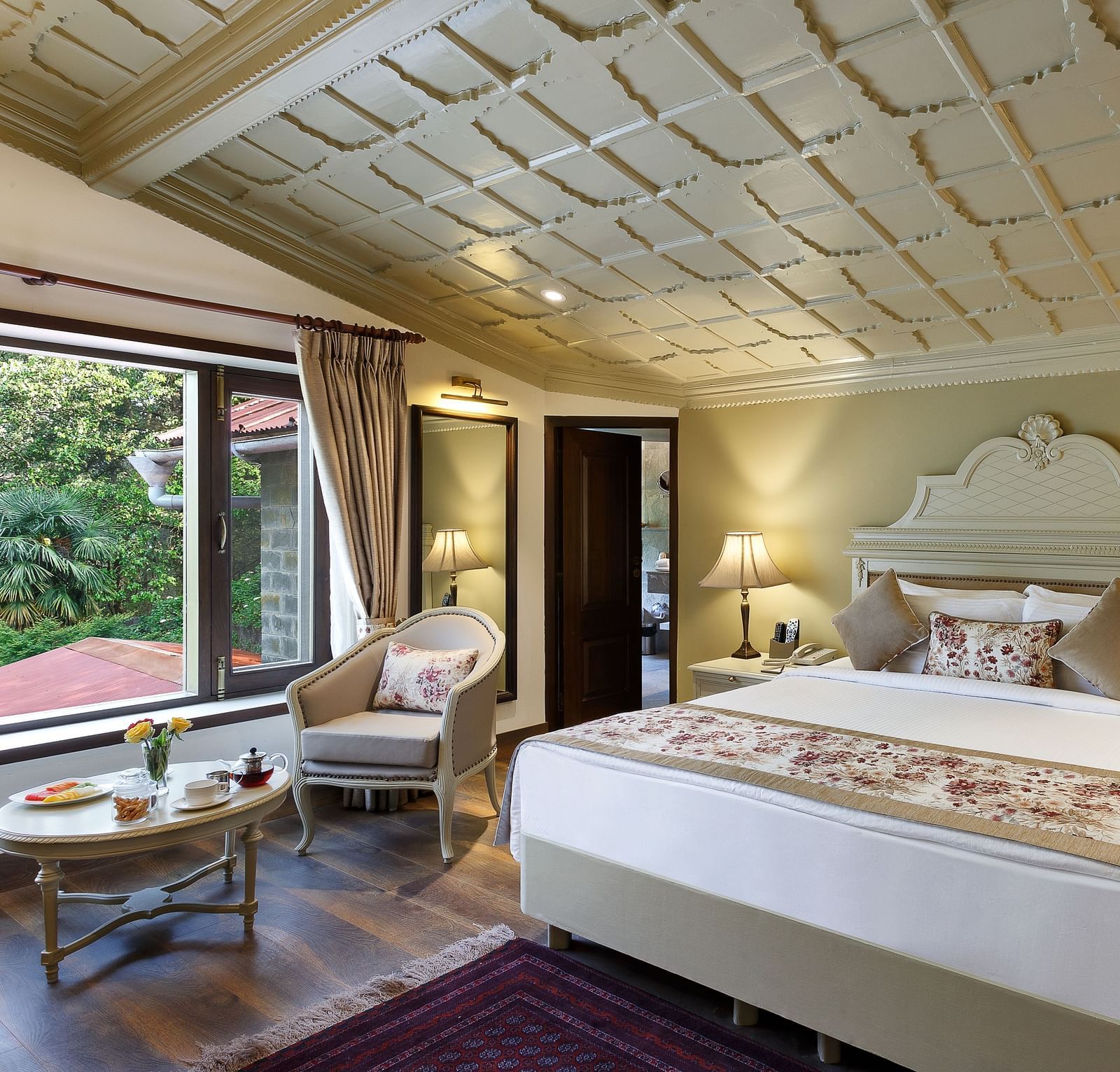 A cosy room with comforting decors, king size bed, wooden ceiling - The Naini Retreat