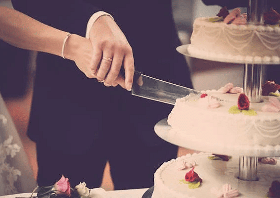 Image of a bride and groom cutting their wedding cake together.