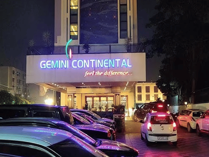 A facade view of Gemini Continental with the sign and many cars parked in front of it in view.