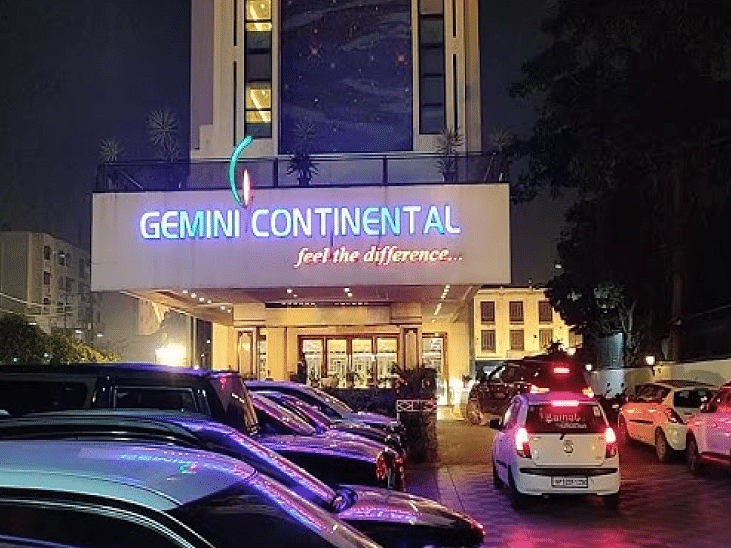 Facade view of Gemini Continental with the signage and many cars parked in front of it in view.