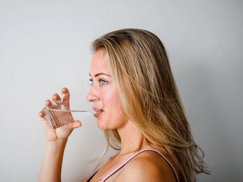 A woman drinking a glass of water