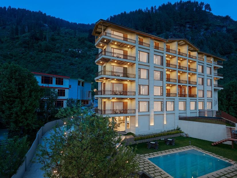 Exterior facade view in the night with the lights on of The Orchid Hotel in Manali.