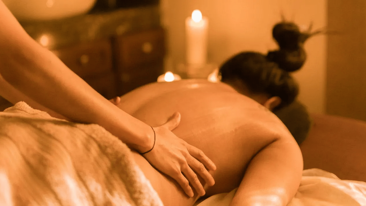 Person receiving a back massage in a spa room at Karma Chalets.