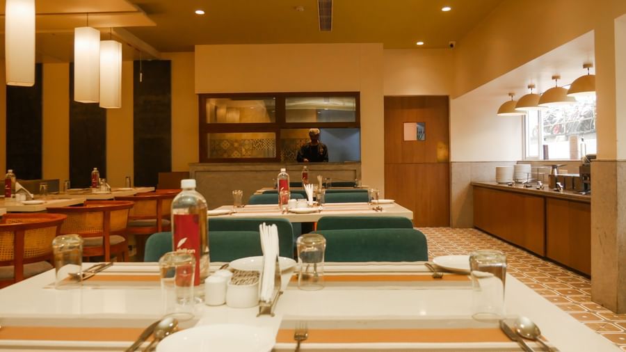 A vibrant restaurant interior with modern decor, comfortable seating, and a buffet counter at Shilton Dee Cee.
