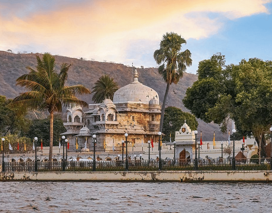  A building with a dome, surrounded by trees, viewed from the lake. 