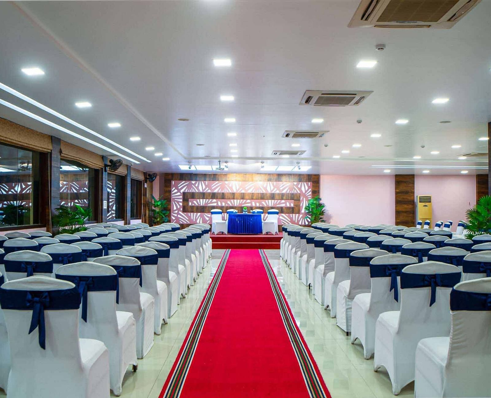 An event room at Mansha Hotel Regency set up with rows of chairs facing a stage, with a red carpet down the aisle.