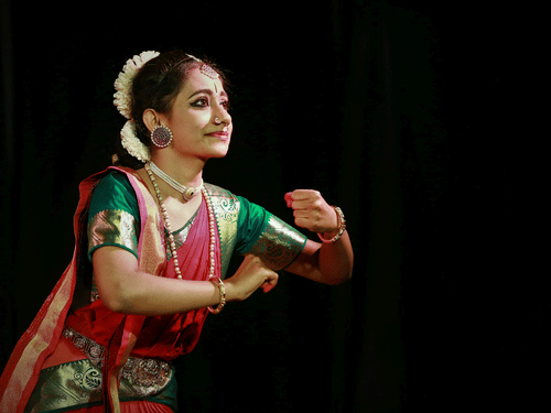 A bharatanatyam dancer performing on a stage.