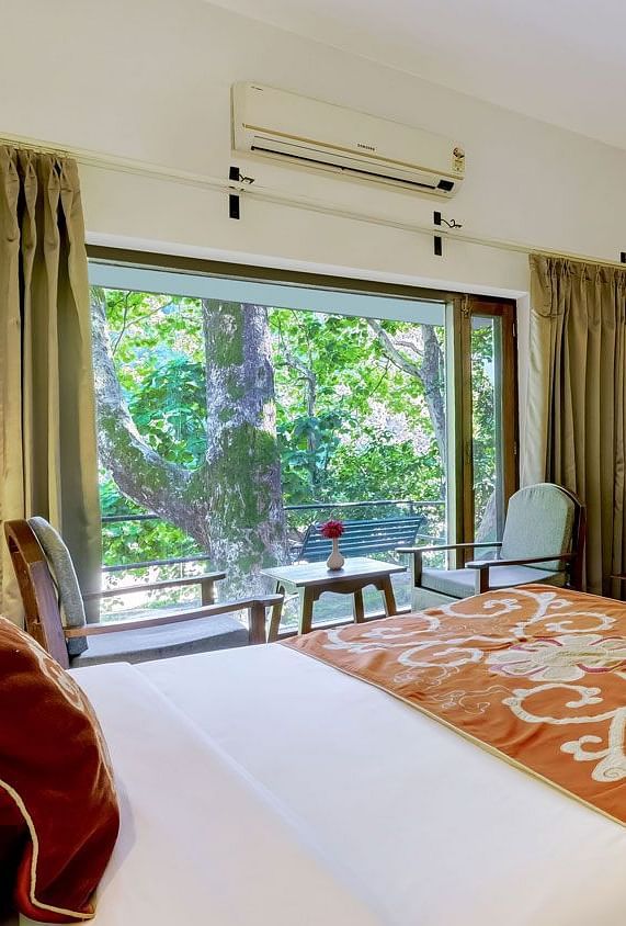 Image of a family room with bed a larg mirror at Summit By The Ganges Beach Resort & Spa, Rishikesh