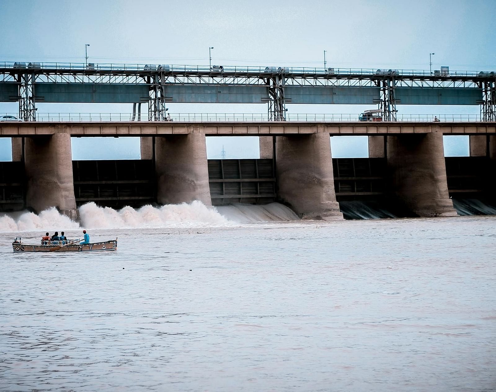 An image of a dam with a boat gliding across the water.