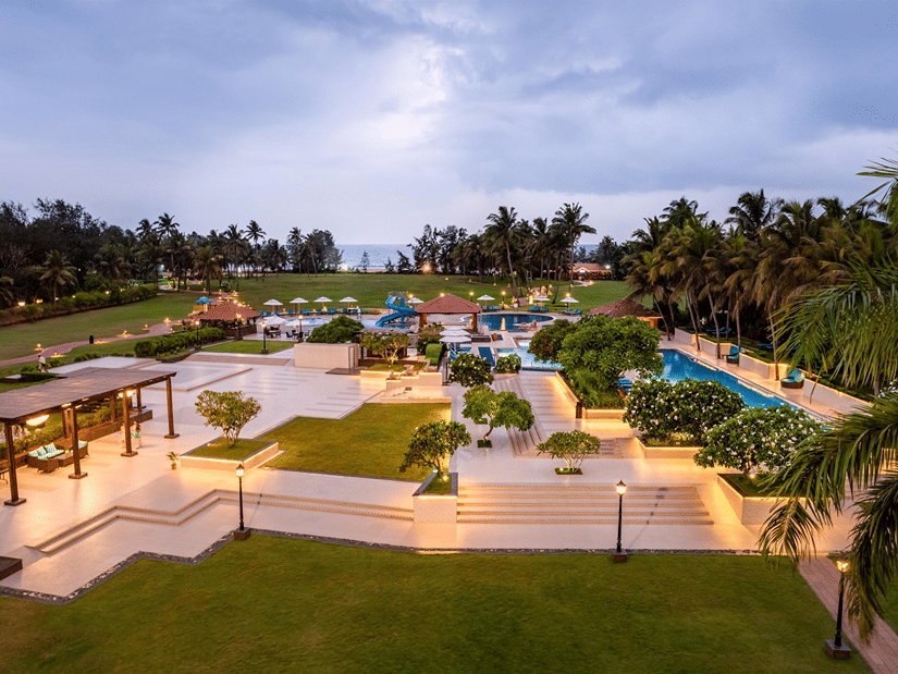 Elevated dusk view of manicured gardens and illuminated pathways at Kenilworth Resort & Spa, Goa.