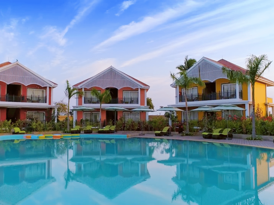 Swimming pool at Swosti Chilika Resort lined by the resort buildings