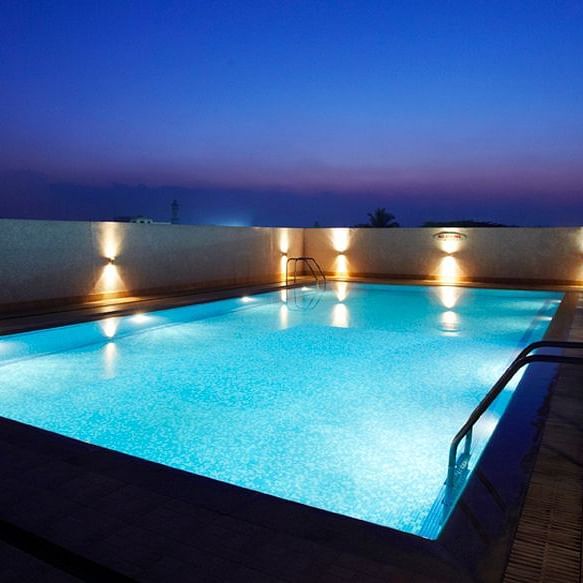 Overview of the swimming pool with lights on on during the night - Hotel Pai Vista, Mysore 