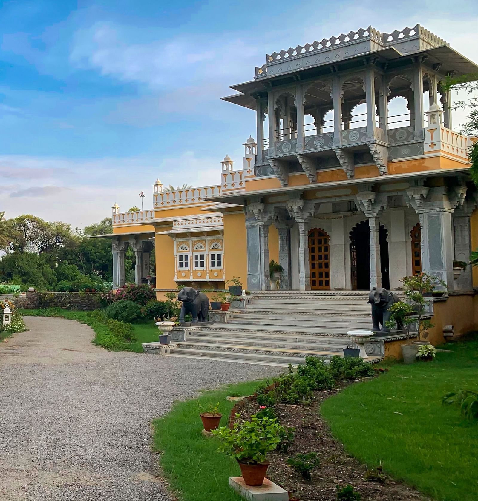 a tranquil Facade image of Dev Shree, Deogarh with a beautiful green lawn in the foreground