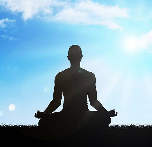 A close image of a person meditating , positioned in the centre.
