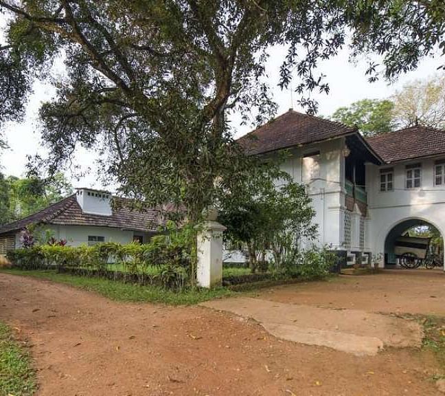 A facade image of serenity at Kanam Estate surrounded by green trees