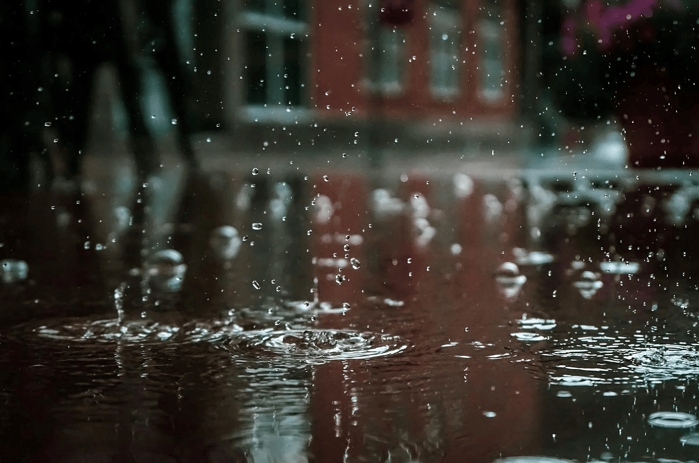Close up shop of rain droplets falling on a flat surface.