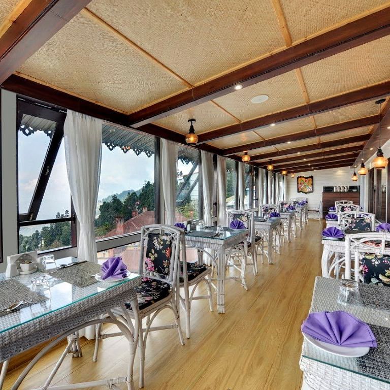 image of a dining space with a slanted roof and lights hanging from the ceiling at Yashshree Mall Road, Darjeeling.
