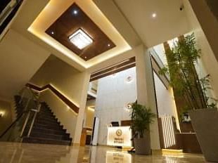A modern lobby with a staircase and a view of the reception area.- Sukhi - A Luxury Stay Inn, Chikkamagaluru
