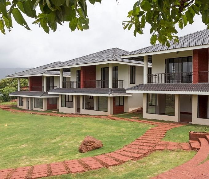 Exterior view of Forest Escapes Resort framed by tree leaves.