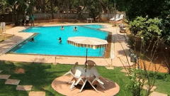 Image of people in the swimming pool at Fantasy Golf Resort in Bangalore on a sunny day