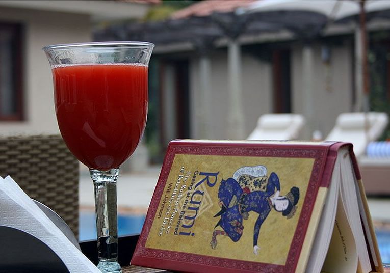 A table set outdoors with a drink, a book with a design - Shreyas Retreat