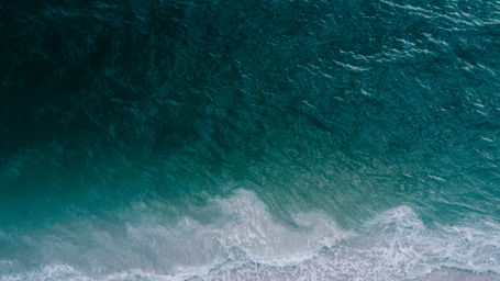 Aerial view of ocean waves meeting the shoreline.