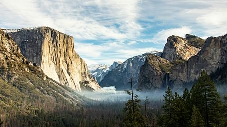 A wide angle view of Yosemite National Park with mountains in the distance.