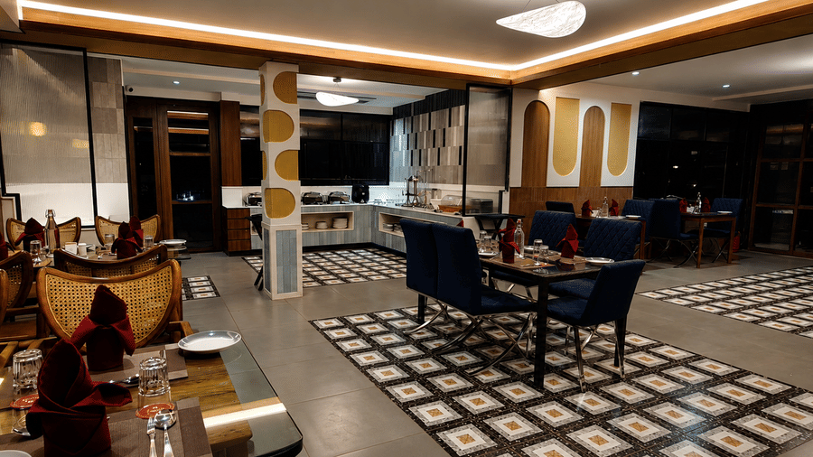 Wide view of the restaurant showcasing patterned flooring, dining tables, the buffet counter, and recessed ceiling lighting at Kali Mirch Restaurant, Lords Riverside Resort, Muduba.