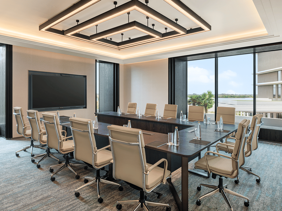 Origin boardroom with a conference table, leather chairs and window view at The Residency Signature Madurai.